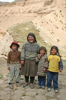 This family lives on hill top above 5000m with their alpacas in the background perched on a cliff. This family lives on hill top above 5000m with their alpacas in the background perched on a cliff.